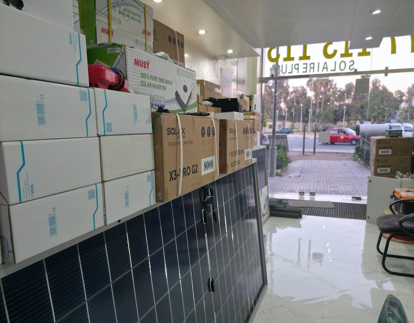 Panneaux photovoltaïques et cartons d'onduleurs alignés dans le local technique